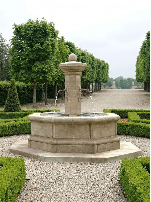 Fontaine de jardin en pierre au centre d'un jardin formel, allées de graviers et alignements d'arbres